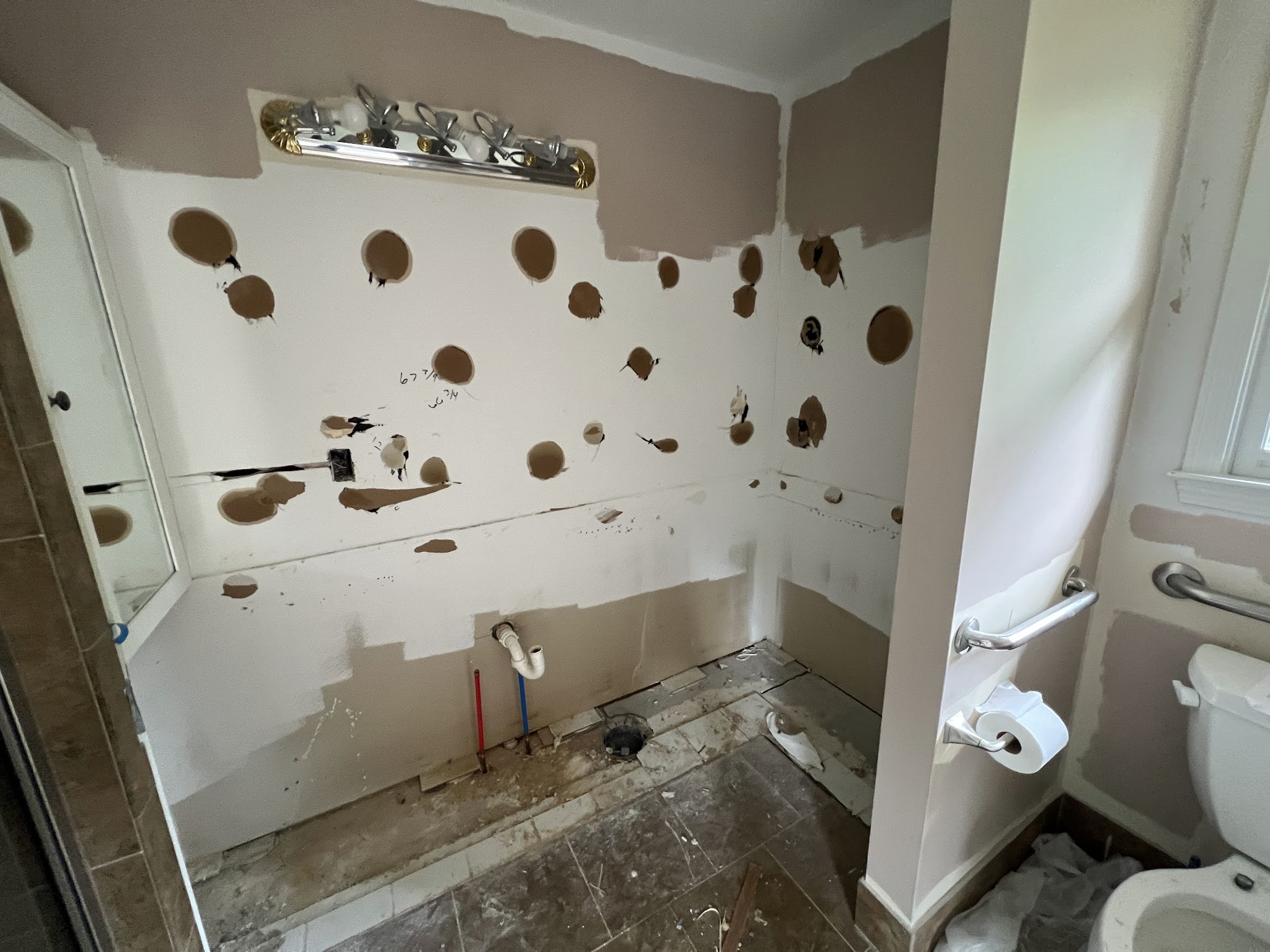 Bathroom vanity area during renovation, with the vanity removed and wall surfaces exposed