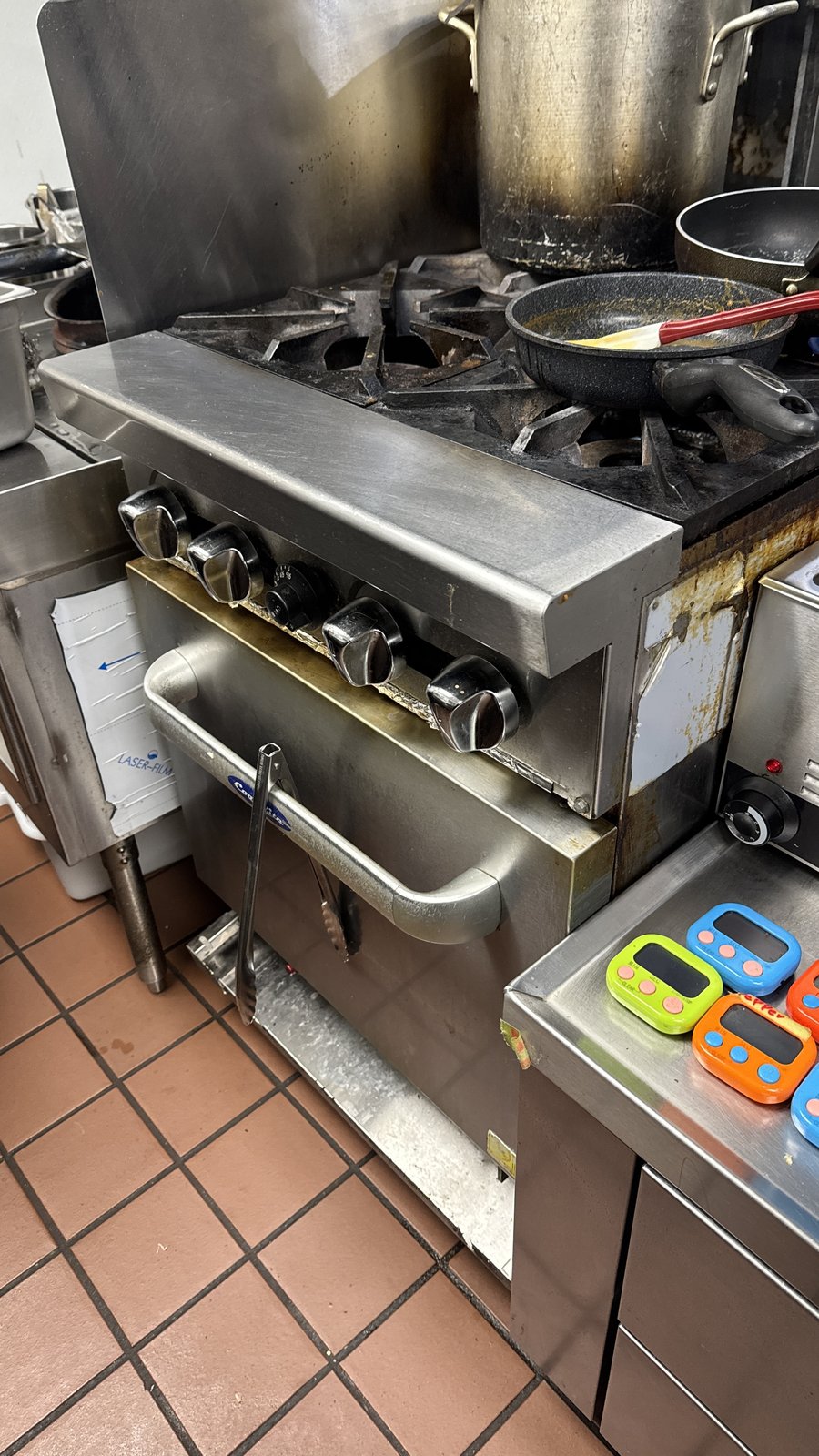 Commercial gas range and oven in a restaurant kitchen.